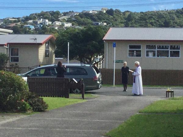 Fr Maurice Carmody praying by a hearse stopped outside is Plimmerton house4